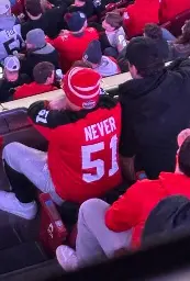 person wearing a red hockey jersey that says never 51