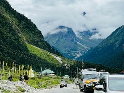 A peaceful mountain road in North Sikkim surrounded by lush hills and mist-covered Himalayan peaks, reflecting the soulful silence of the journey.