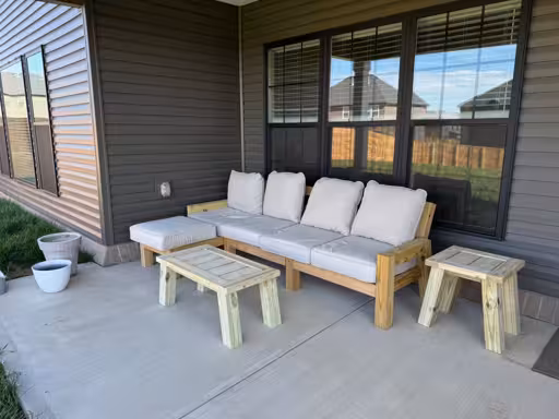 Wooden sectional with chaise. A matching wooden coffee table and side table are adjacent.