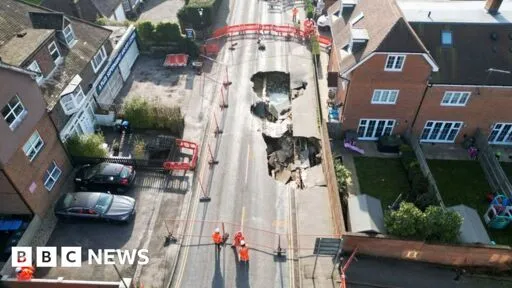 Godstone: Huge sinkhole swallows up more of Surrey street - BBC News